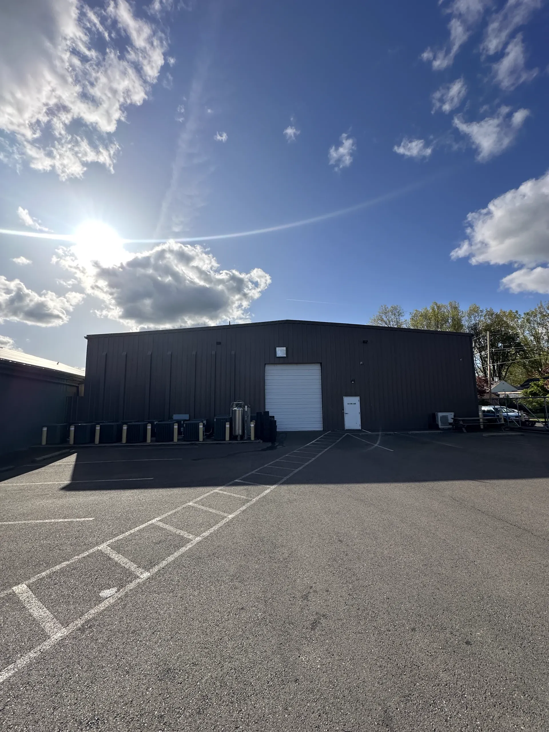 Exterior view of the Oregon Greens Salem cultivation facility under blue sky and afternoon sun